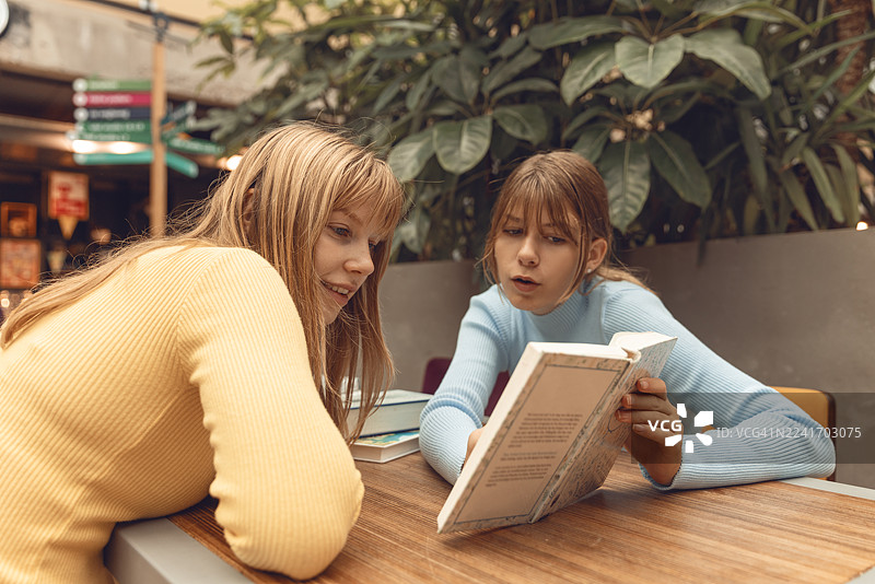 两个十几岁的姐妹在图书馆一起学习图片素材