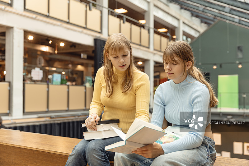 两个十几岁的姐妹在图书馆一起学习图片素材