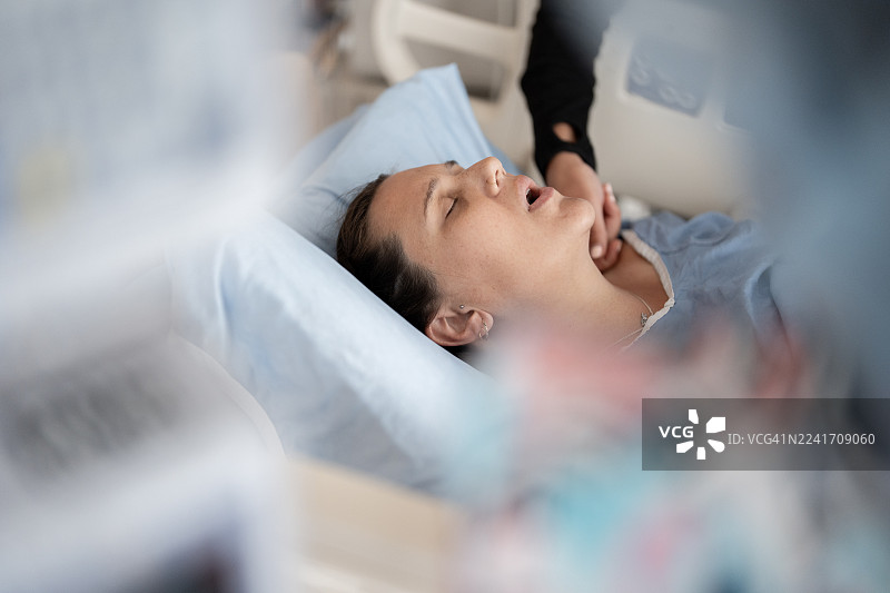 孕妇在助产士的陪伴下，在医院病床上即将迎来分娩时刻图片素材