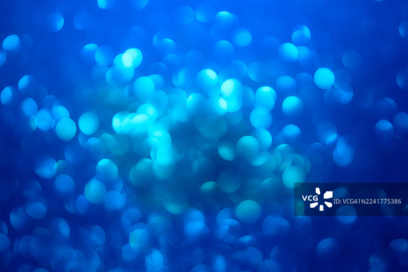 蓝色散景灯光：带有圆形辉光效果的柔和环境抽象背景图片素材
