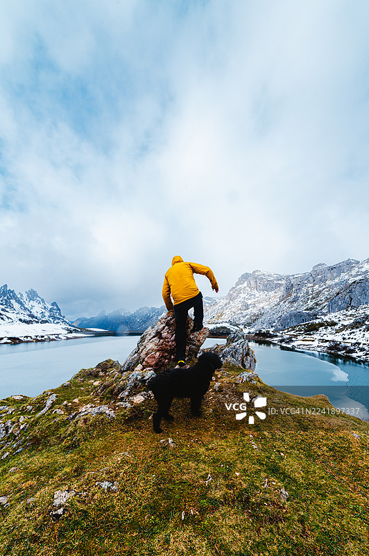 一名男子和他的狗在索姆耶多自然公园徒步穿越山间湖泊图片素材