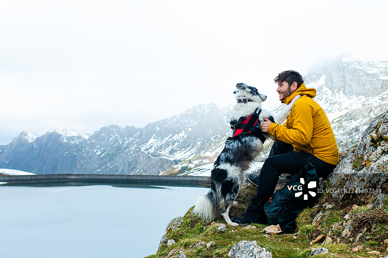 男人和狗在山间徒步时建立深厚感情图片素材