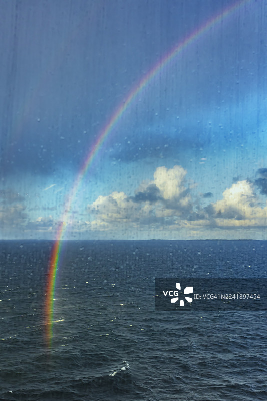 雨中透过窗户看到的波罗的海上空的双彩虹图片素材