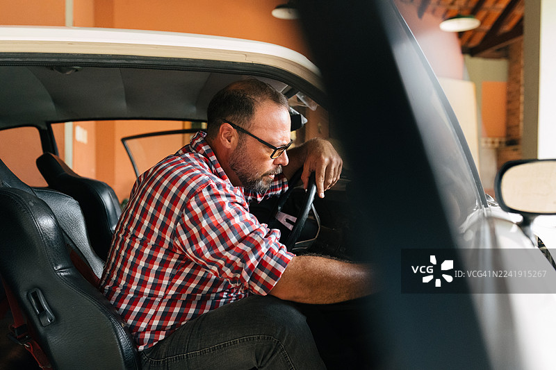男子检查经典汽车内饰图片素材