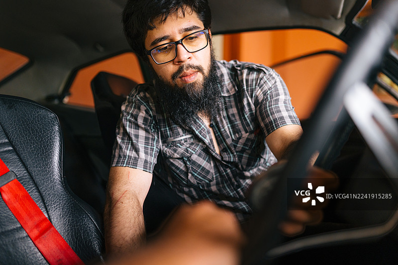 男人在经典车内调整方向盘图片素材