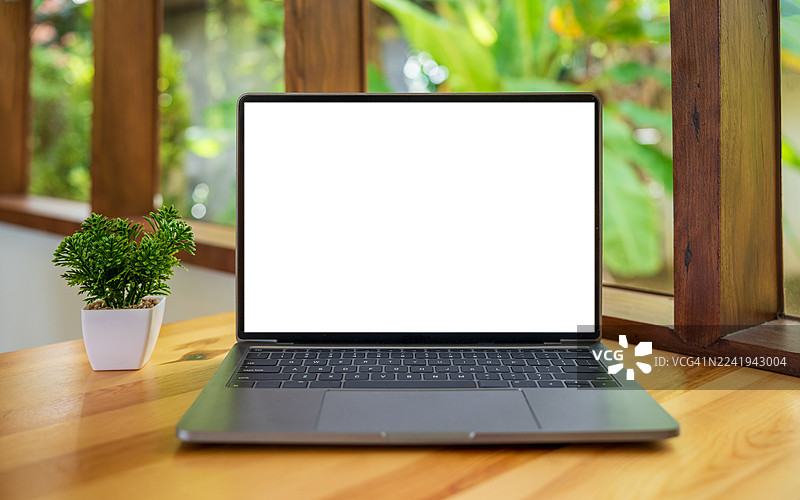 咖啡馆背景桌上的笔记本电脑空白屏幕。带有复制空间的笔记本电脑屏幕。舒适的工作场所。正面视图。网上冲浪。视频会议。在线购物。图片素材
