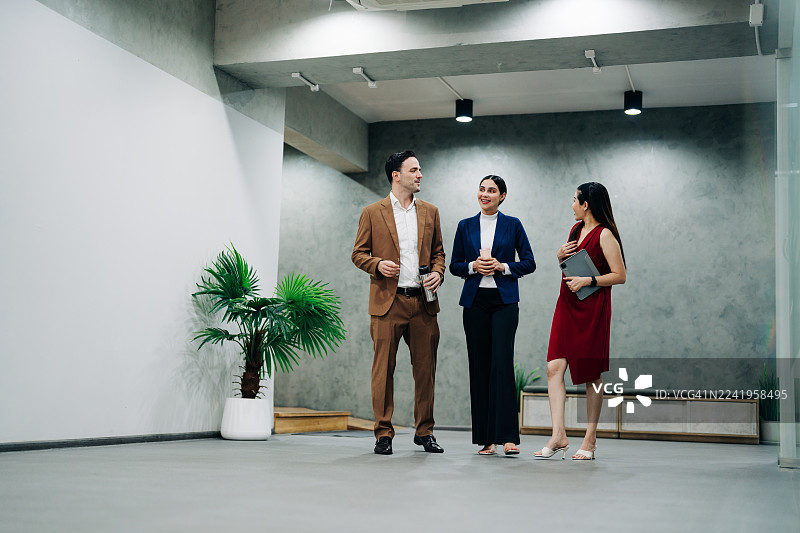 商务团队在现代企业办公室里边走边交流图片素材