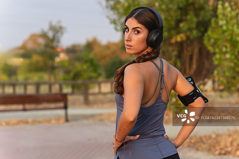 戴着耳机、表情坚毅的女性运动员看向镜头图片素材