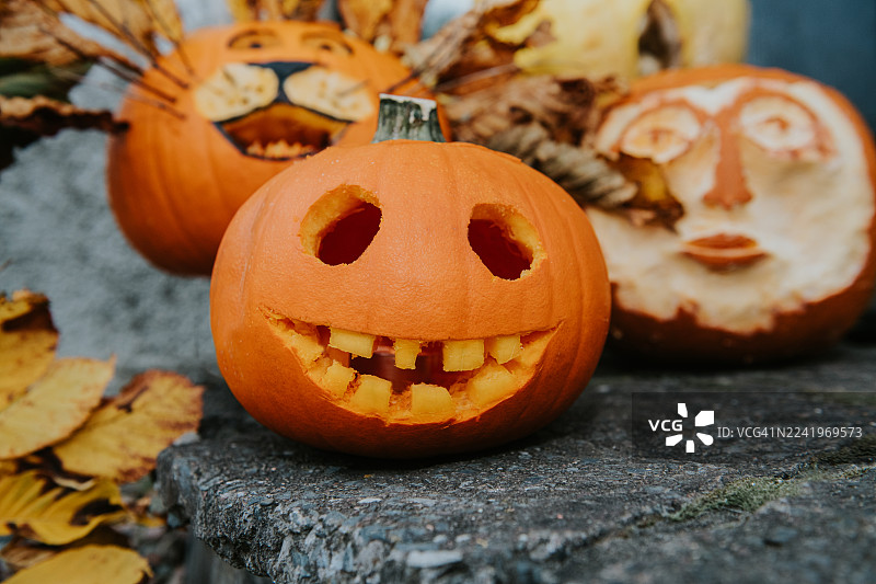 万圣节期间，各种雕刻的南瓜灯摆放在门口，具有选择性对焦。图片素材