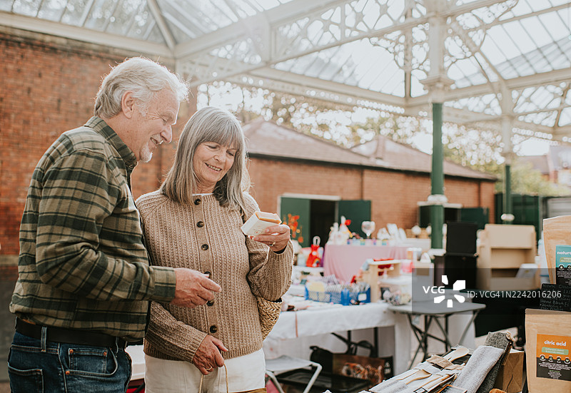 一对成熟的夫妇在市场摊位上浏览肥皂图片素材