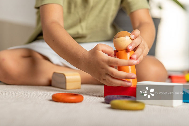 一个孩子在地毯上玩彩色的积木，进行创意游戏图片素材
