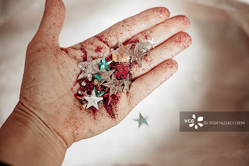 一只手掌张开，展示着闪亮的闪光和闪耀的尘埃图片素材
