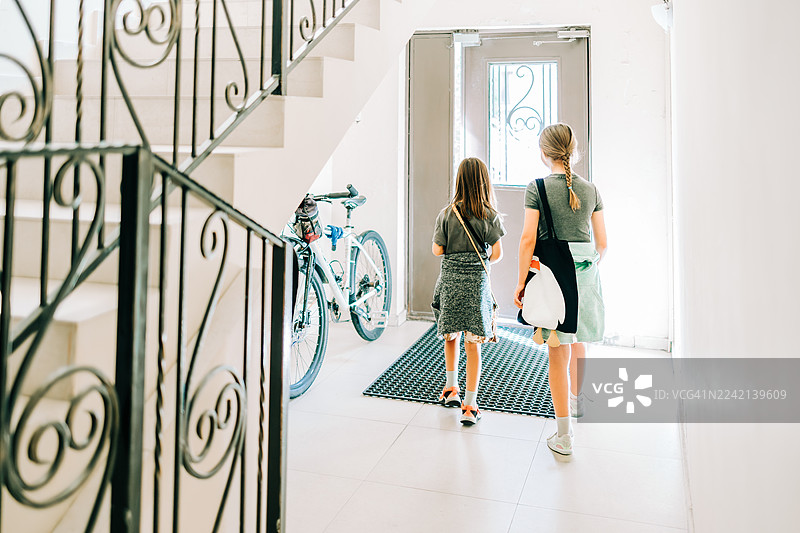 女孩们走在走廊里走向房门，离开家图片素材