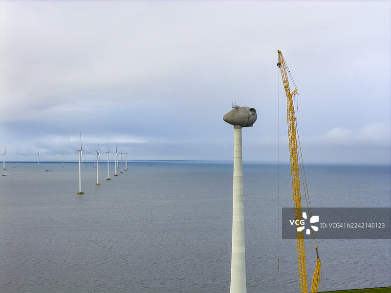风力发电场建设中的风力涡轮机，配有巨大的起重机图片素材