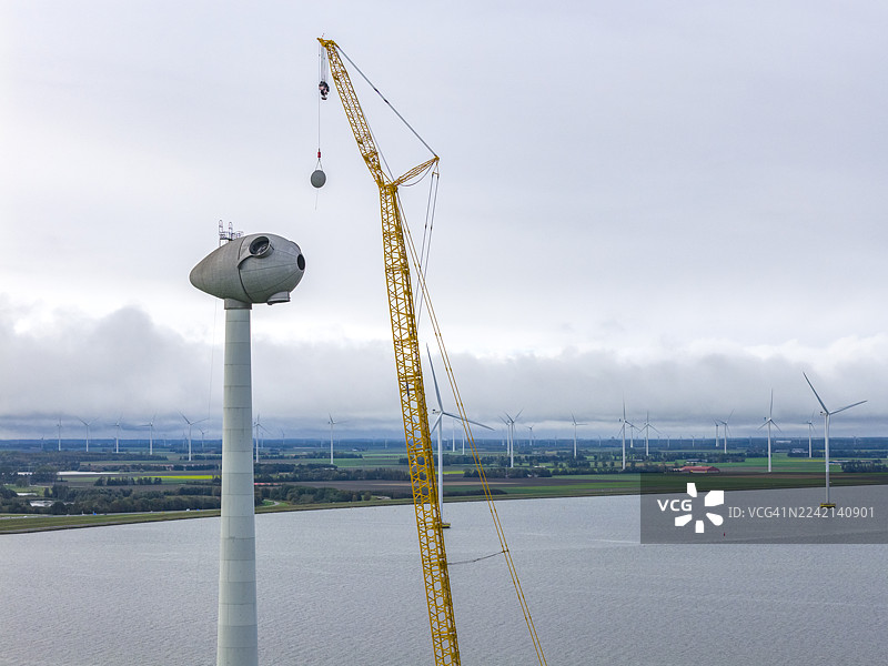 风力发电场巨型起重机正在建设风力涡轮机图片素材