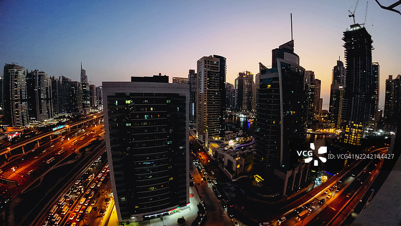 迪拜码头 - 暮光时分现代城市天际线，下方灯火辉煌，车流涌动。图片素材