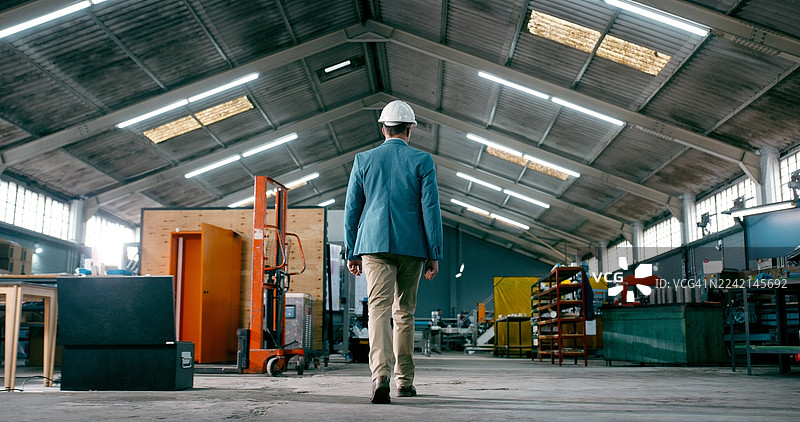 制造，戴着个人防护装备的工人在仓库里行走，进行工厂更新或物料库存检查。在仓库中，空间、后勤和工业总监正在进行现场检查、生产或安全管理。图片素材