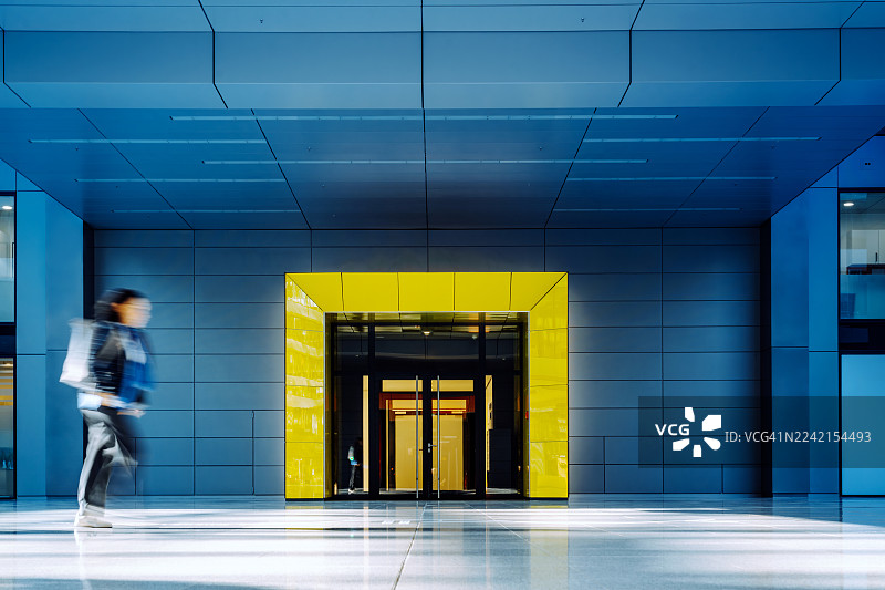 模糊的女性走在现代建筑内图片素材