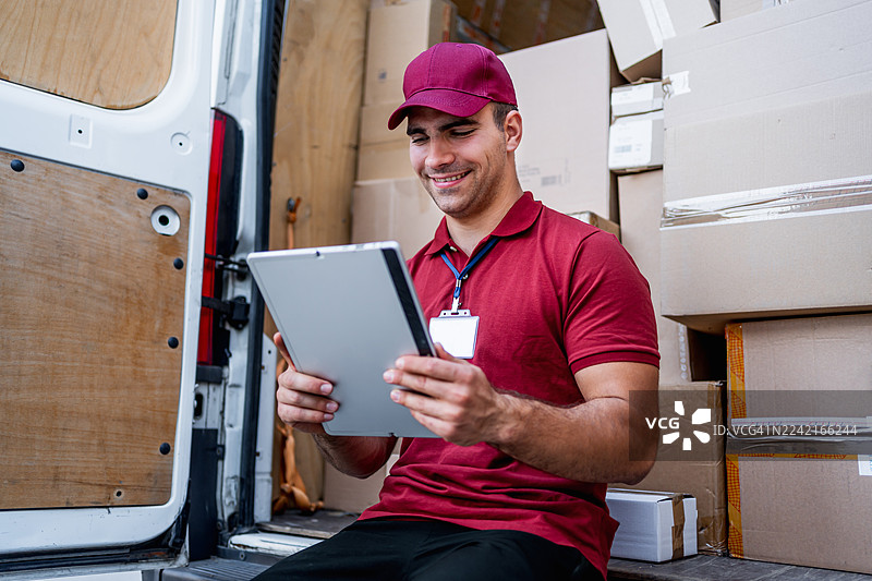 送货员在平板电脑上核对包裹信息图片素材