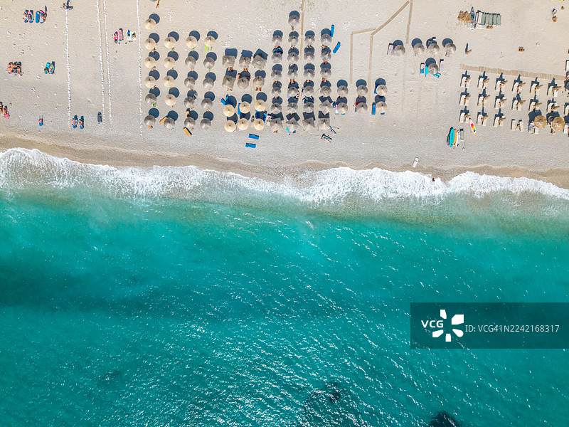 无人机视角下的整齐海滩遮阳伞与海岸线图片素材