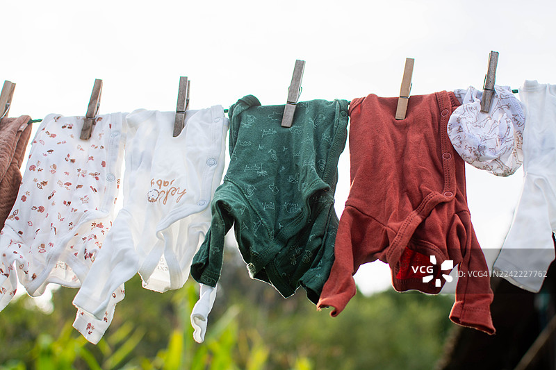 婴儿衣服在户外晾衣绳上晾晒图片素材