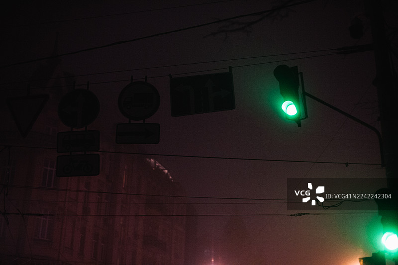 雾气弥漫的城市街道上的绿色交通信号灯图片素材