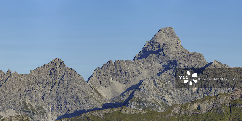 从科布拉特高地小径俯瞰内贝尔峰，远处是奥伯塔尔的葱郁草地，以及高耸的霍赫沃格尔和罗斯扎恩山脉，其中霍赫沃格尔海拔2592米，位于德国巴伐利亚州阿尔高地区。图片素材