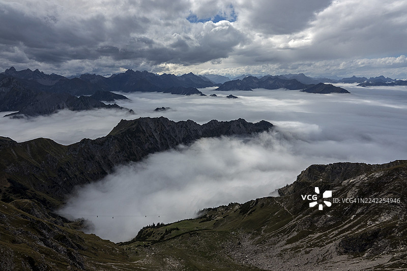从内贝尔峰(Nebelhorn)山顶望去,阿尔高阿尔卑斯山(Allgäu Alps)的山峰从山谷的雾气中升起,地点为上阿尔高(Oberstdorf, Oberallgäu, Allgäu),巴伐利亚(Bavaria),德国(Germany)。图片素材