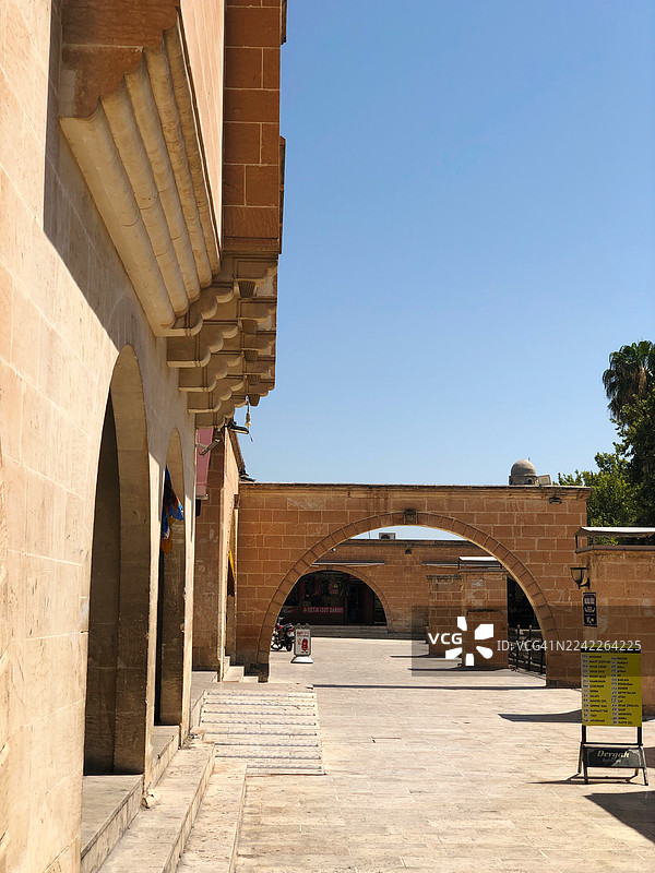 晴朗的蓝天下，土耳其鲁哈（Ruha, Turkey）历史建筑的全景，带有拱门和石砌建筑图片素材