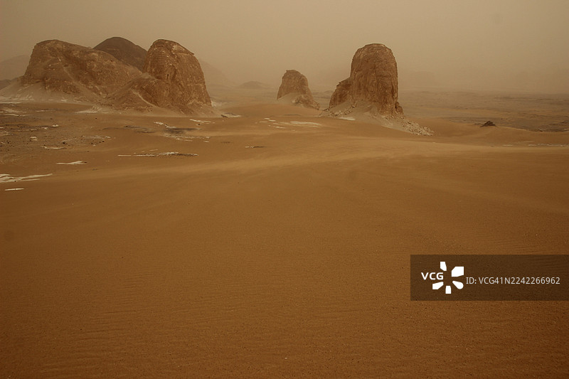 苍茫沙漠风光，高耸的岩石地貌在朦胧的天空下，展现大自然的辽阔图片素材