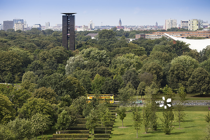 郁郁葱葱的绿树和现代建筑在湛蓝的天空下构成充满活力的城市景观，一辆双层巴士从中驶过，柏林，德国，柏林圣诞集市图片素材