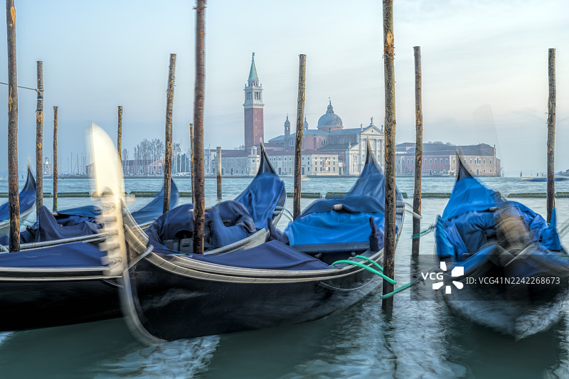 贡多拉船停泊在威尼斯运河中，背景是圣乔治马乔雷教堂，意大利威尼斯，Euronet Finance图片素材