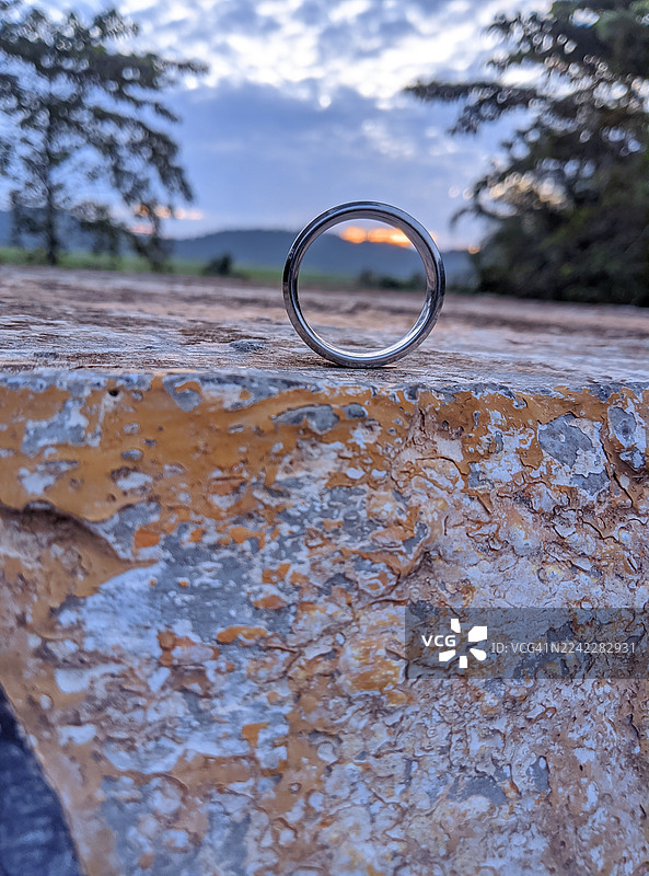 夕阳背景下，纹理保留墙上戒指的特写图片素材