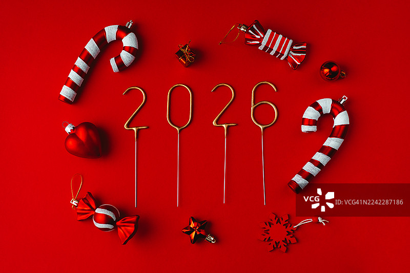 红底背景上，金色的闪光数字2026，周围环绕着拐杖糖、一颗心、一颗星星、一片雪花和一个小礼品盒。图片素材