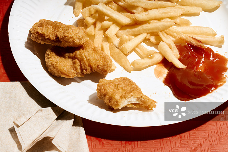 餐盘里装着炸薯条、鸡块、番茄酱和餐巾纸图片素材
