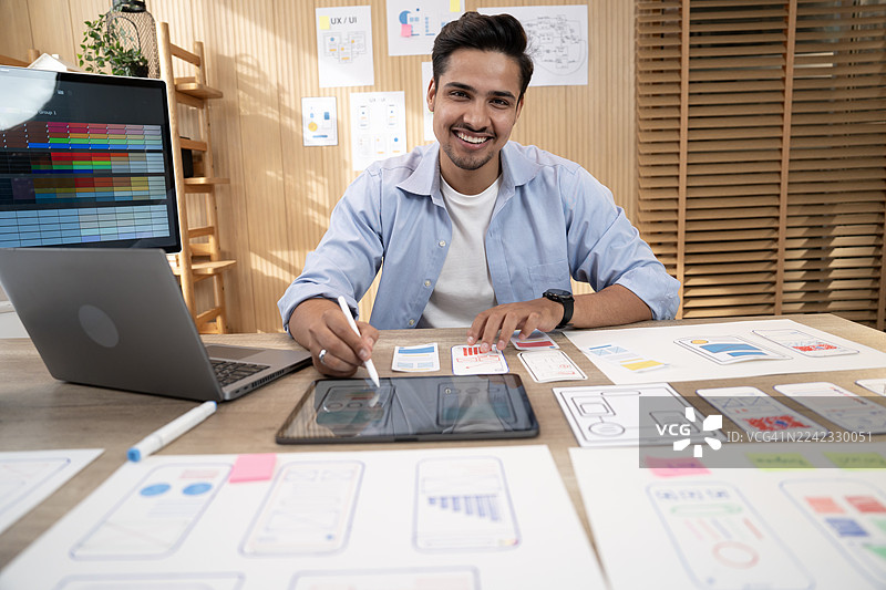 UX/UI设计师在网站和移动应用程序设计概念中，围绕着用户流程草图和设计工具，为网站和移动应用程序原型绘制线框图。图片素材