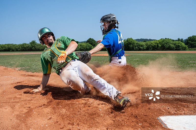 激烈的比赛时刻，棒球捕手触杀跑垒员图片素材