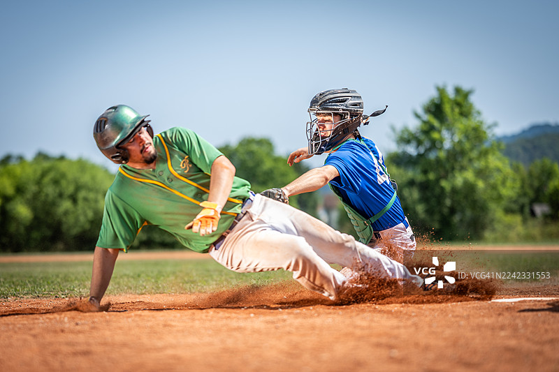 棒球比赛中，年轻的高加索男性接球手防守本垒图片素材