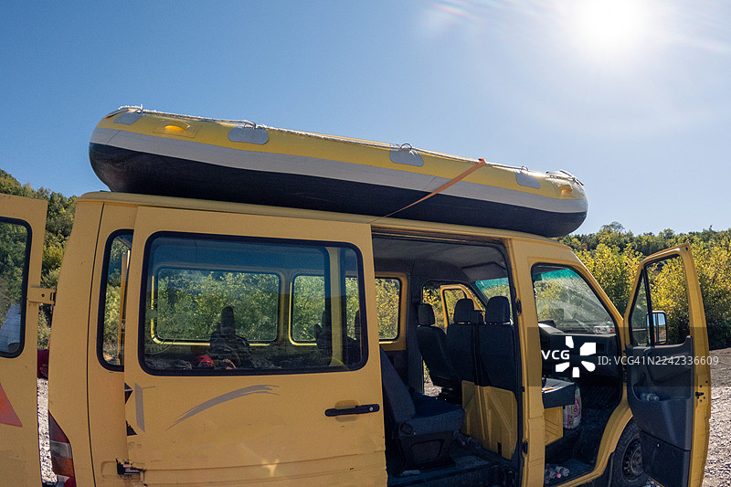 车顶载有充气艇的黄色货车图片素材