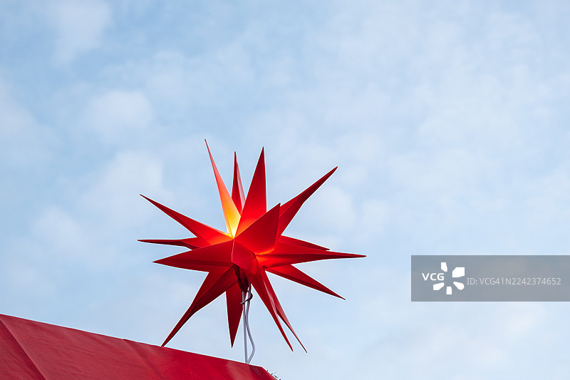 红色的圣诞之星映衬着晨曦的天空图片素材