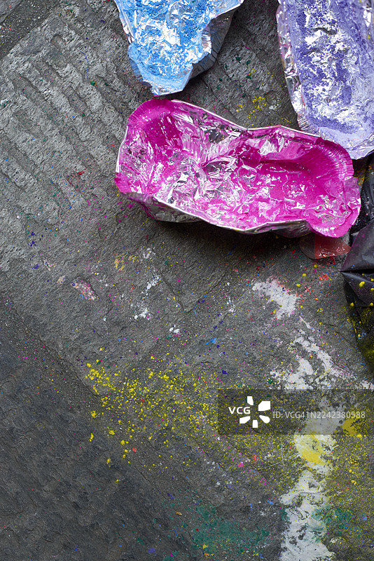 彩色粉末泼溅在深色纹理路面上图片素材
