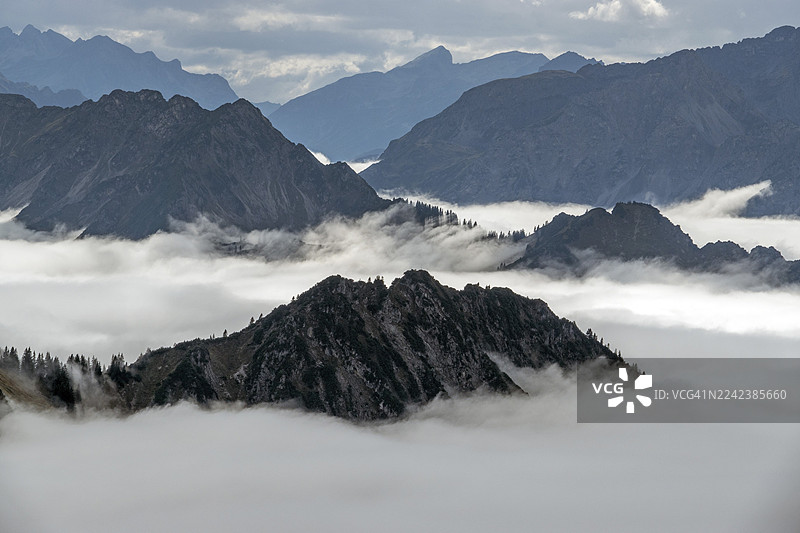 从内贝尔峰顶看到的阿尔高阿尔卑斯山脉,山峦从山谷的雾气中升起,奥伯斯多夫,上阿尔高,阿尔高,巴伐利亚,德国图片素材