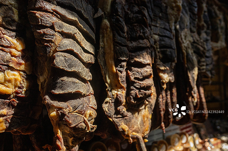 特写镜头，展示了悬挂在乡村市场展示架上的深色风干牛肉干图片素材