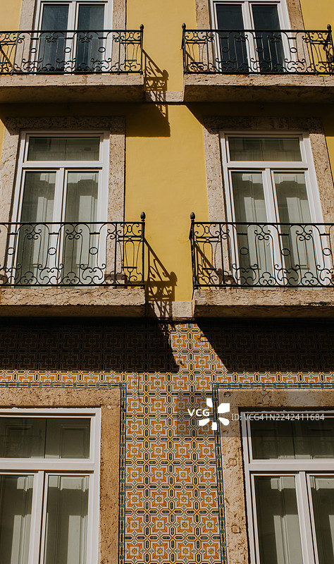 阳光明媚的一天，在充满活力的街区里，一座拥有华丽瓷砖装饰的古老建筑。图片素材