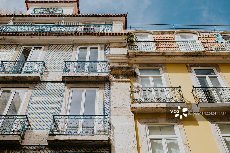 阳光明媚的一天，充满活力的街区里一座拥有华丽瓷砖装饰的旧建筑图片素材