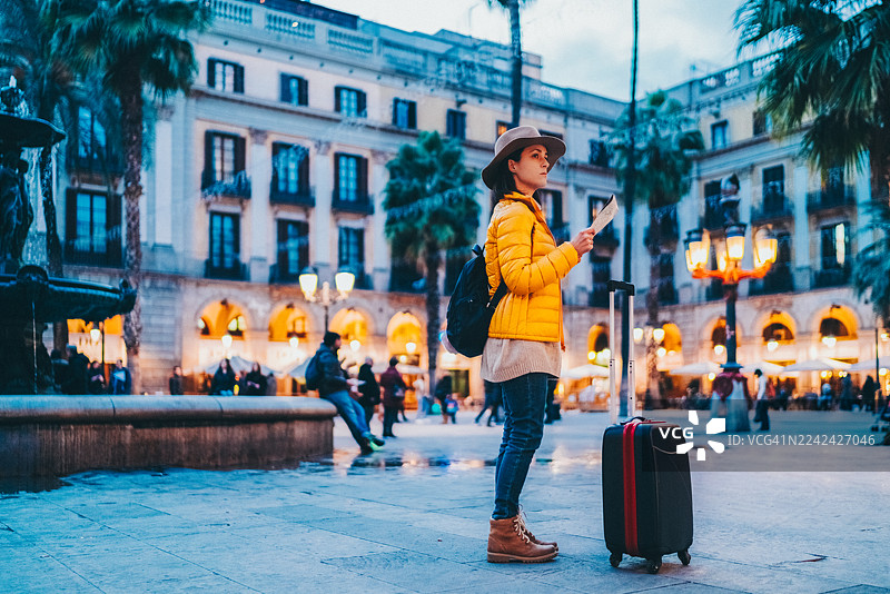独自旅行者在巴塞罗那广场的喷泉旁看地图图片素材