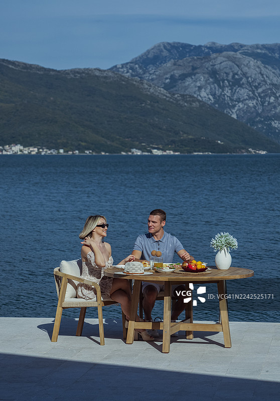 年轻情侣在度假时在海边享用早午餐图片素材