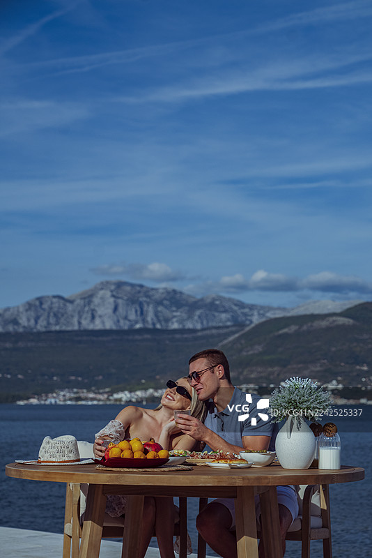 年轻情侣在假期享受海滨早午餐图片素材