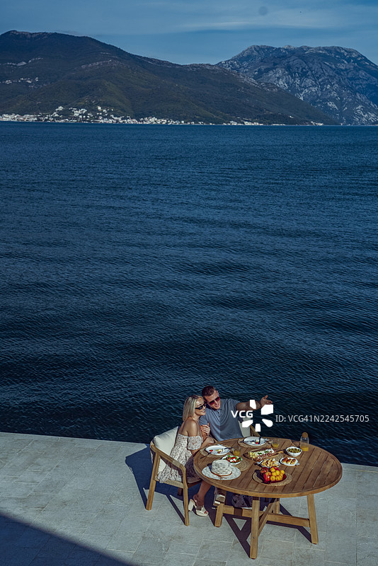 一对幸福的情侣在海边享用早午餐，共度美好时光图片素材