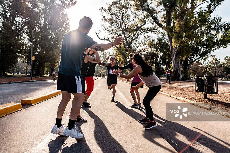 朋友们在公园庆祝马拉松赛后图片素材
